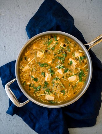 Pot of tofu soup with mizuna greens.